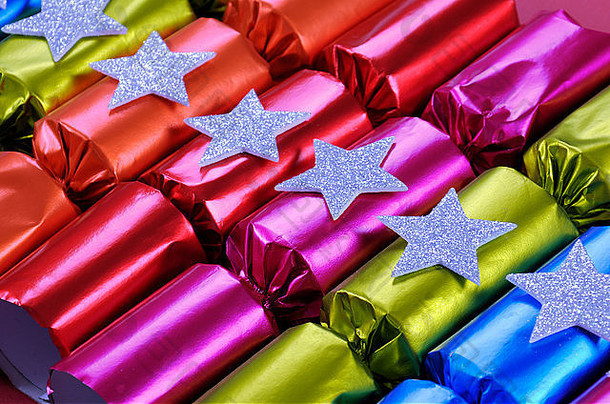 一排闪亮的圣诞饼干棒棒糖，颜色有鲜艳的红色、粉色、橙色、蓝色和绿色。角