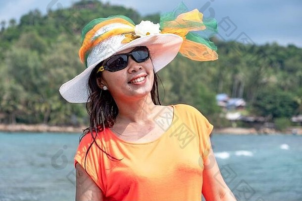 描绘年轻美丽的泰国女士在假日的海滩、大海和海洋上散步、微笑和快乐，进行休闲旅行