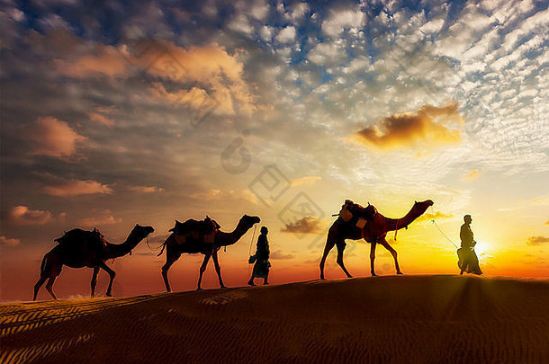 在塔尔德塞的沙丘上，两名骆驼手牵着骆驼