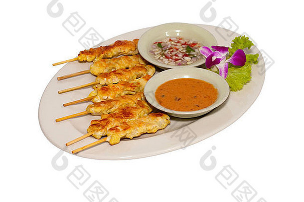 沙爹鸡泰国开胃菜，酱汁和花卉装饰，白色背景。