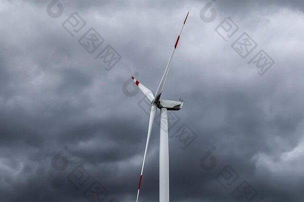 以黑色风暴云为背景拍摄风力涡轮机生产可再生能源的特写镜头