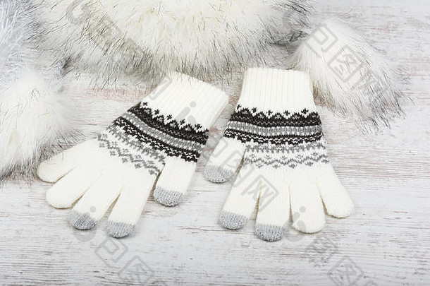 白色木质背景的冬季针织手套