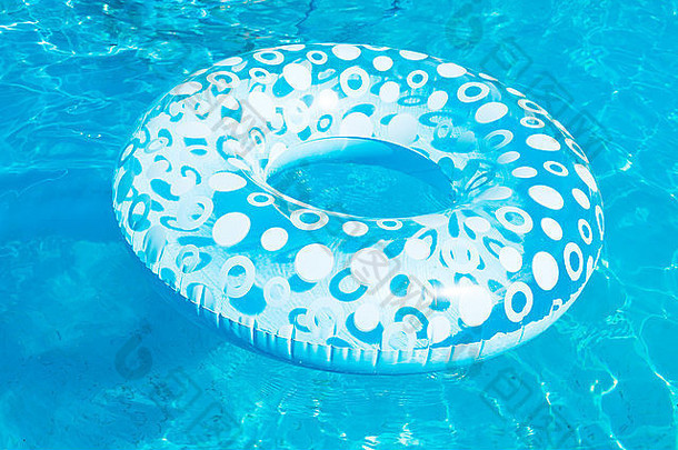 夏日蓝色露天游泳池中的充气游泳圈