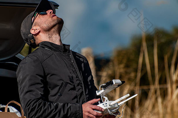无人机飞行员驾驶远程控制智能手机手森林天空
