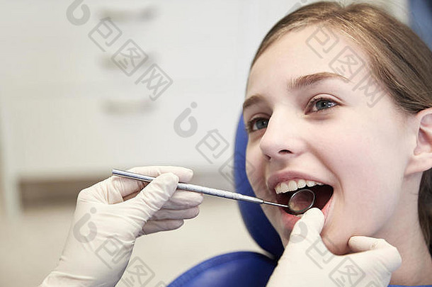 用牙科镜检查女孩牙齿的手