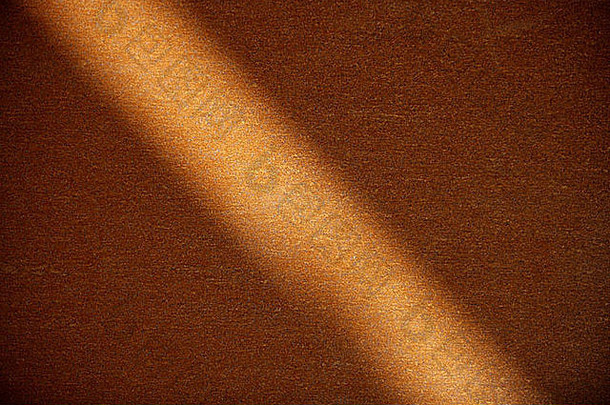 锈钢橙色背景纹理。穿过表面的光束
