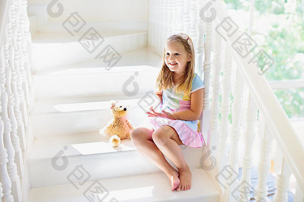 在白宫走楼梯的小孩。小女孩在阳光明媚的楼梯间玩耍。一家人搬进新家。儿童攀登现代楼梯的台阶。门厅