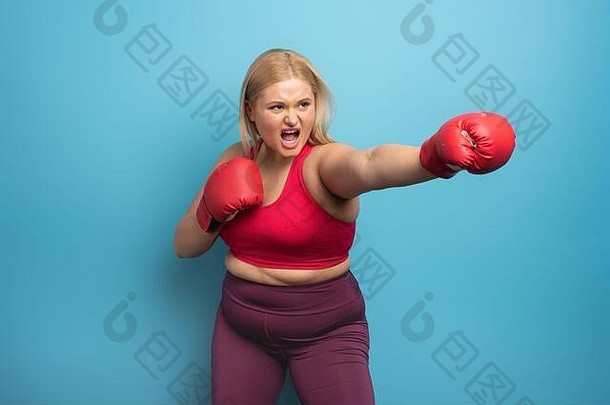 健身室里的胖女孩<strong>打拳击</strong>。青色背景