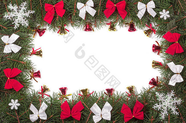 圣诞框架由冷杉树枝制成，装饰有蝴蝶结和铃铛，在白色背景上隔离开来