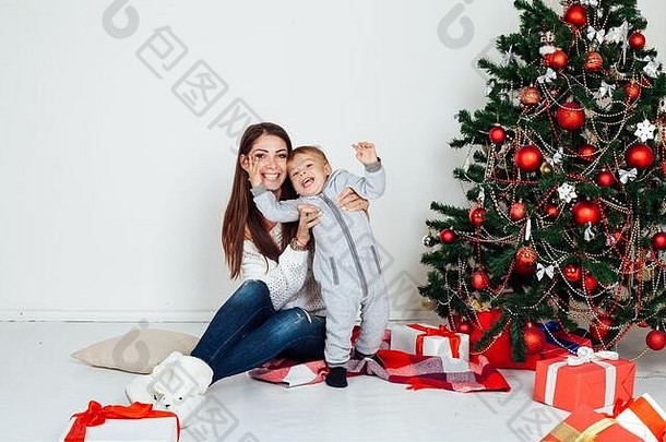 妈妈和小男孩在圣诞树旁拿着礼物