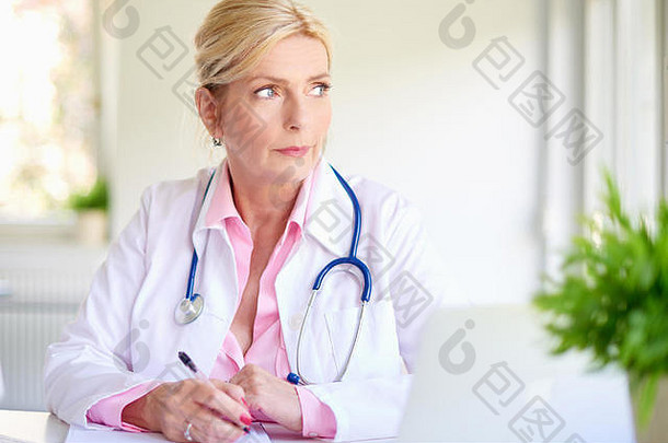 特写镜头肖像高级不知所措女医生坐着医疗房间深思熟虑写作