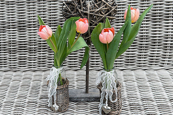 两个花瓶，粉红色郁金香花和心形，以竹子为背景，纪念母亲节