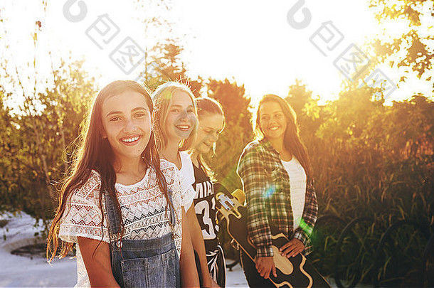 一个十几岁的女孩和朋友在背景中看着相机