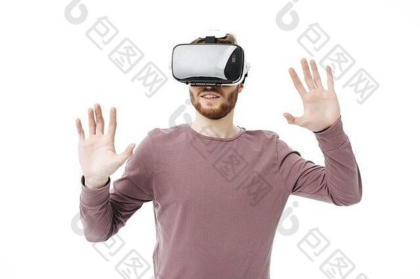 在白色背景上使用虚拟现实眼镜的年轻微笑男子的肖像。<strong>酷男孩</strong>快乐地玩着虚拟现实眼镜