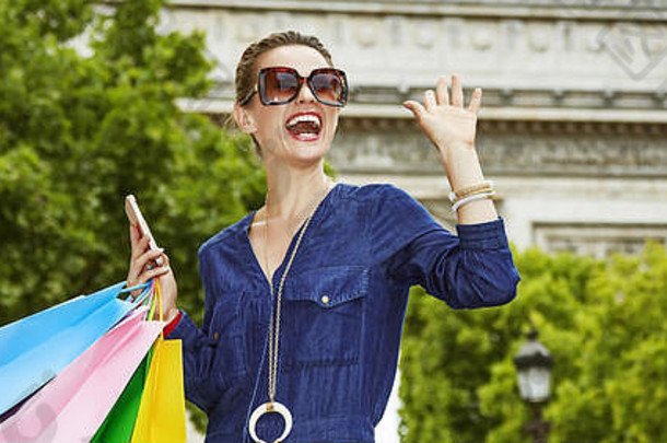 袋准备好了巴黎购物微笑年轻的时尚的女人购物袋智能手机挥臂巴黎法国