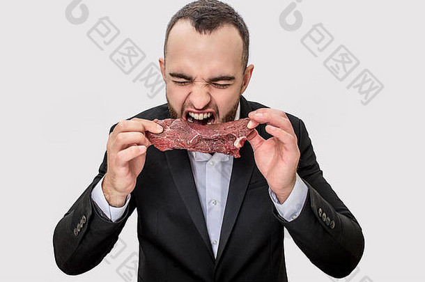 图片年轻的商人尖叫大喊大叫持有一块生肉的家伙咬孤立的白色背景