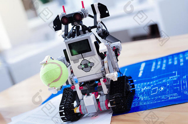 一个智能创新机器人拿着网球的特写镜头