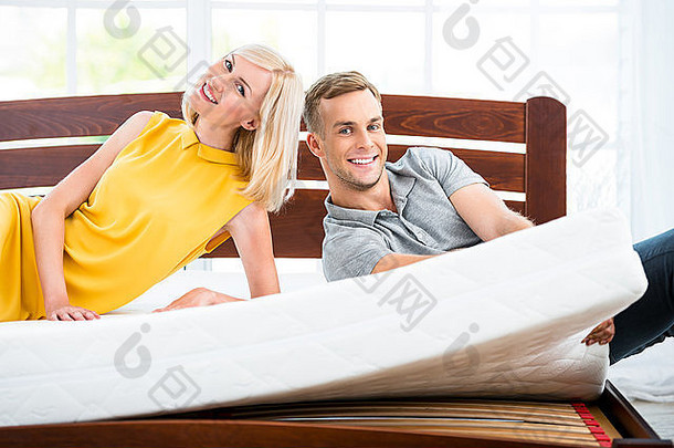 坐在白色床上的年轻夫妇