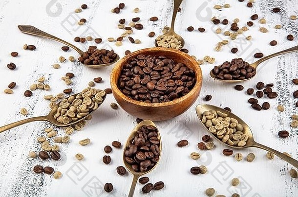 白色木桌上的各种优质复古咖啡豆勺。生咖啡豆、微烤咖啡豆和双烤咖啡豆。