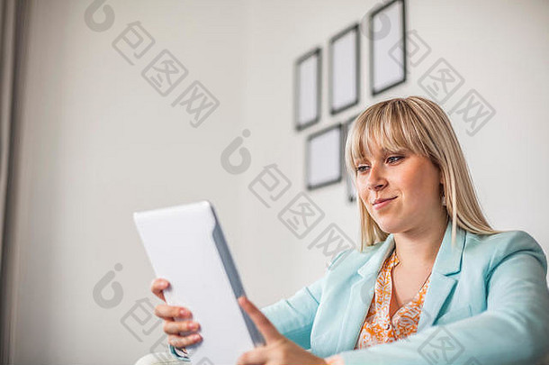 自信的年轻女商人在办公室使用数字平板电脑