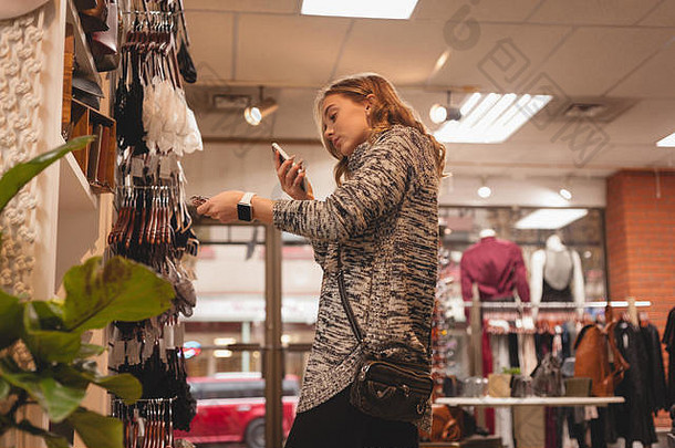 在商场购物时使用手机的妇女
