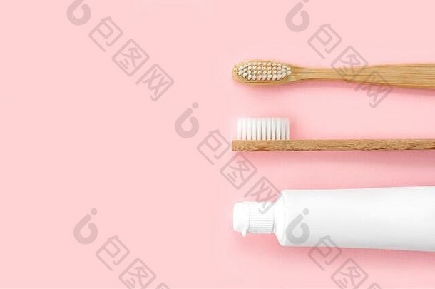 粉色背景的环保牙刷和牙膏套装。牙科和保健概念。俯视图，平面布置。免费拷贝空间。