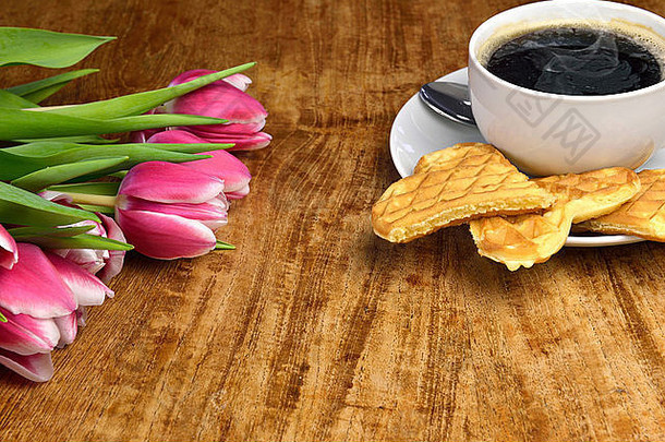 新鲜的郁金香，一杯热气腾腾的咖啡和新鲜烘焙的华夫饼干