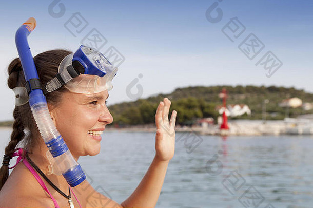 海边的可爱女孩戴着潜水面具，挥手向你问好