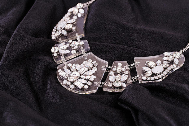 黑色面料背景上镶有宝石的时尚项链。