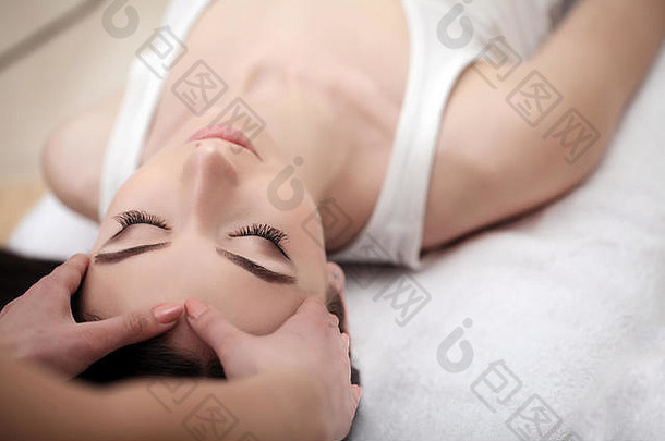皮肤和身体护理。一位年轻女子在美容院接受水疗的特写镜头。Spa面部按摩。面部美容治疗。温泉沙龙。