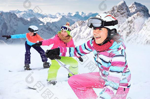 两个十几岁的女孩和一个女人在山上滑雪