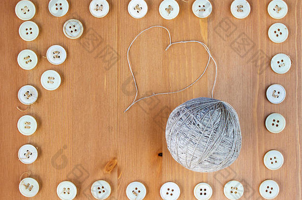 旧的缝纫纽扣框架和亚麻线在中间的球。平面布置，俯视图。拷贝空间