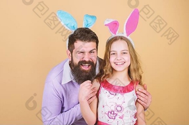 孩子们的复活节活动。复活节快乐。节日兔子长耳朵。家庭传统观念。家里的爸爸和女儿都戴着兔子耳朵。父亲和孩子庆祝复活节。春假。复活节。