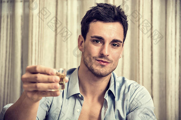 迷人英俊的年轻男子坐着喝酒