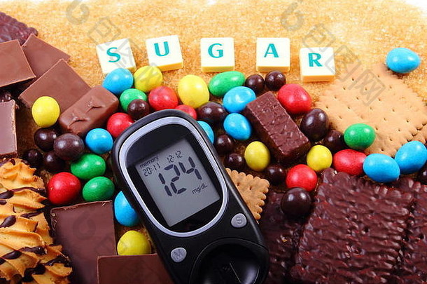 血糖仪上有糖这个词，一堆糖果，饼干和红蔗糖，太多<strong>的</strong>糖果，不健康<strong>的</strong>食物，<strong>糖尿病的</strong>概念