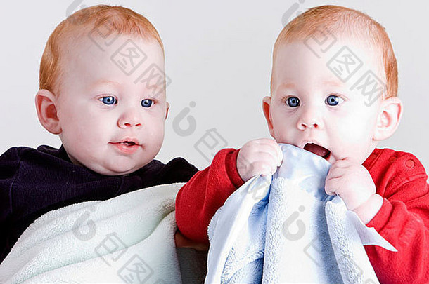 穿着毛毯的可爱双胞胎男孩