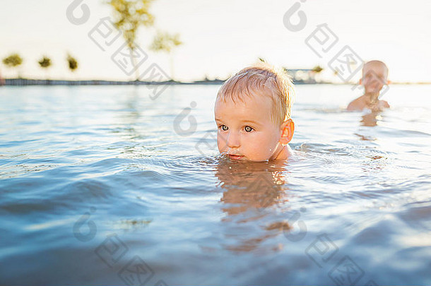 在阳光明媚的<strong>夏日</strong>，小男孩们在水里<strong>游泳</strong>