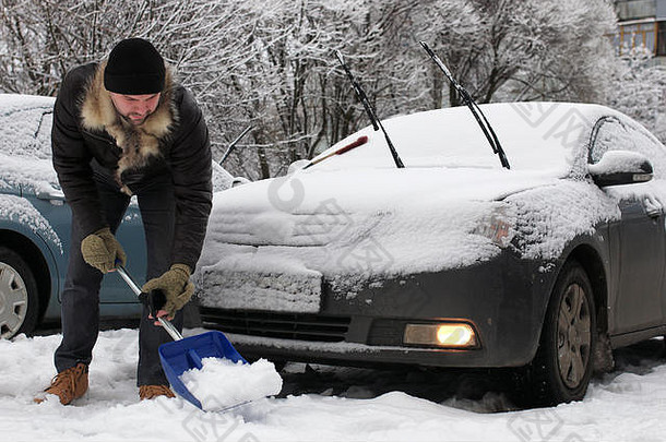 一个冬天的早晨，一个男人在汽车上的雪