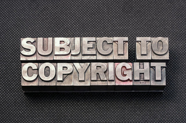 受版权保护短语由黑色穿孔表面上的金属凸版印刷块制成