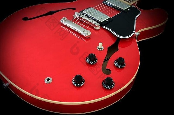 吉布森ES-335半空心电吉他的细节，显示了音孔、humbucker拾音器、桥接器、音量和音调旋钮、选择器开关、拾音器、樱桃饰面和装订。