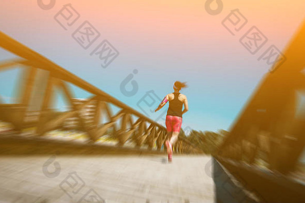 抽象运动模糊：年轻女子在夏日海边慢跑越野跑。健身理念与健康生活方式