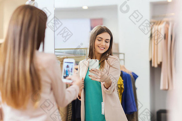 女人采取镜子自拍智能<strong>手机</strong>商店