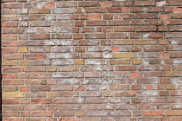 旧红砖墙显示出老化和砂浆腐烂的迹象。