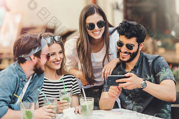 快乐朋友智能手机享受时间夏天咖啡馆