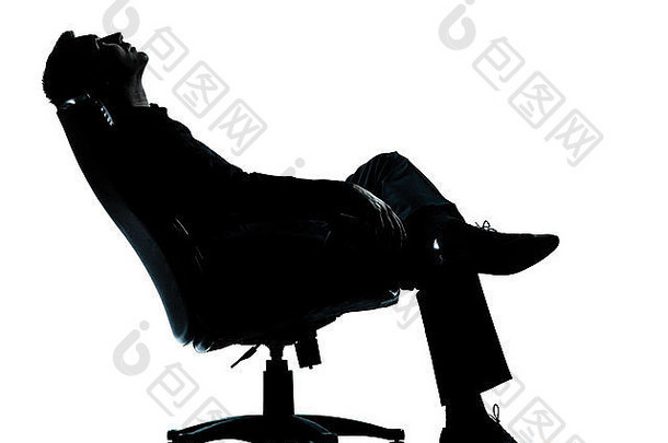 一位白种人商人坐在扶手椅上放松思考，在白色背景下的工作室里，他的剪影是全长的