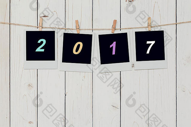 四个相框和2017年新年文本悬挂在白色木质<strong>背景</strong>上，留有空间。