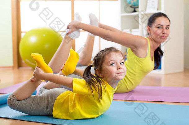 母亲和孩子在家在地毯上做健身运动