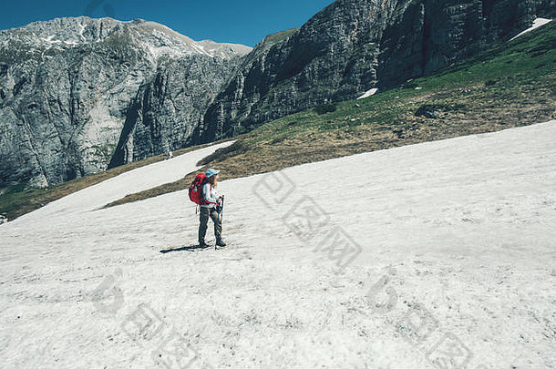 旅行者带着背包在山上徒步旅行旅行生活方式概念探险积极的暑假户外到野外