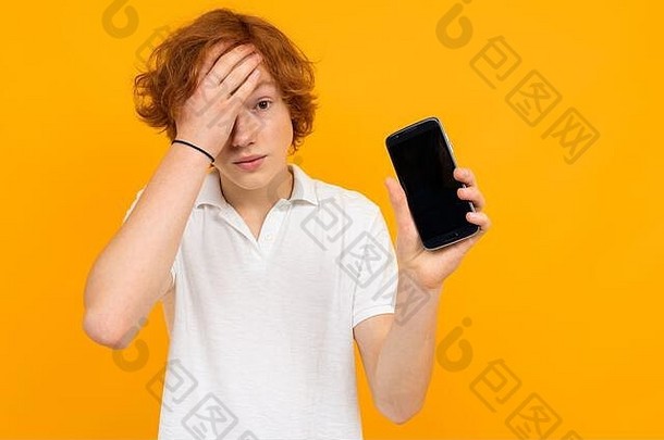 一个穿着白衬衫的高加索人手里拿着一个智能手机，在黄色背景上有一个空白的模版，上面有复印空间