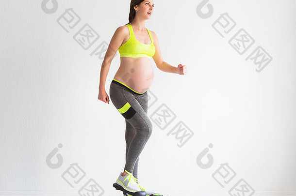 年轻的怀孕了女人健身练习工作室